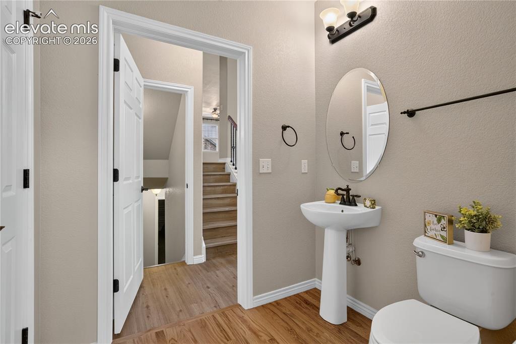 Image 10 of 43: Powder room featuring a white pedestal sink with an oil-rubbed bronze fauce