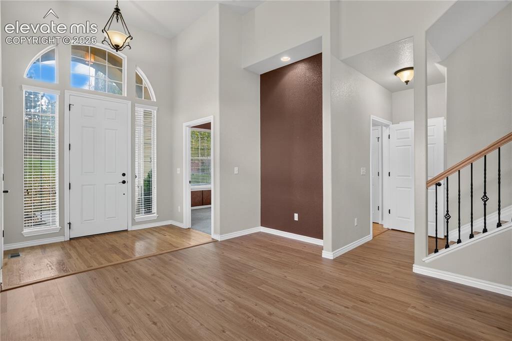 Image 11 of 43: Foyer featuring soaring ceilings, wood-finish flooring, an arched transom w