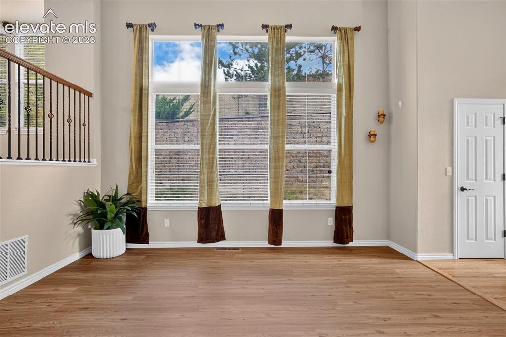 Image 12 of 43: High-ceiling interior featuring a floor-to-ceiling grid of windows, wood-fi