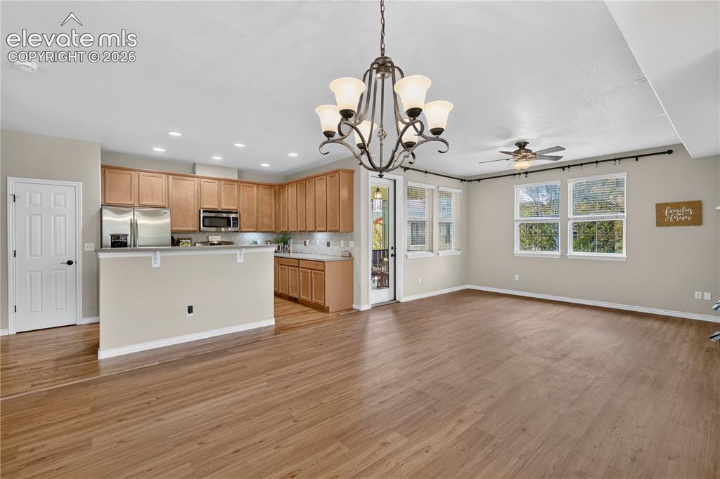 Image 14 of 43: Open-concept with luxury vinyl and natural wood flooring, a kitchen, chande