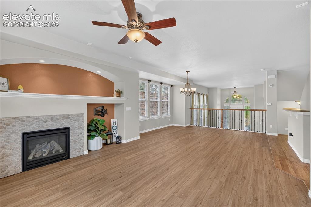 Image 19 of 43: Fireplace with stone-style surround, arched recessed alcove, wood-finish fl