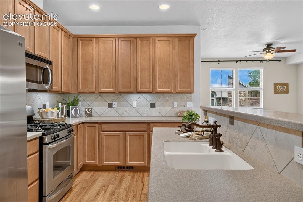 Image 21 of 43: Kitchen featuring wood cabinetry, stainless steel appliances, dual-basin si