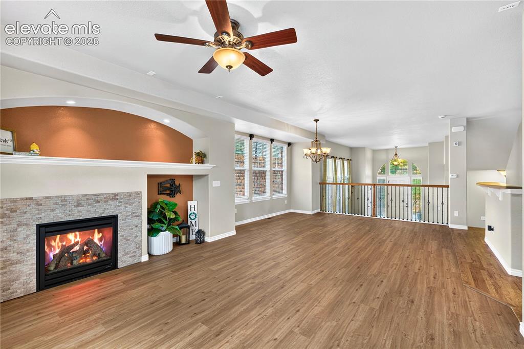 Image 3 of 43: Cozy gas fireplace anchors this part of the open concept living/dining area