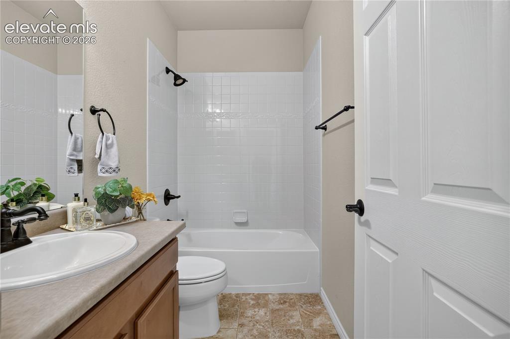 Image 33 of 43: Hall bath with tile surround tub/shower combo