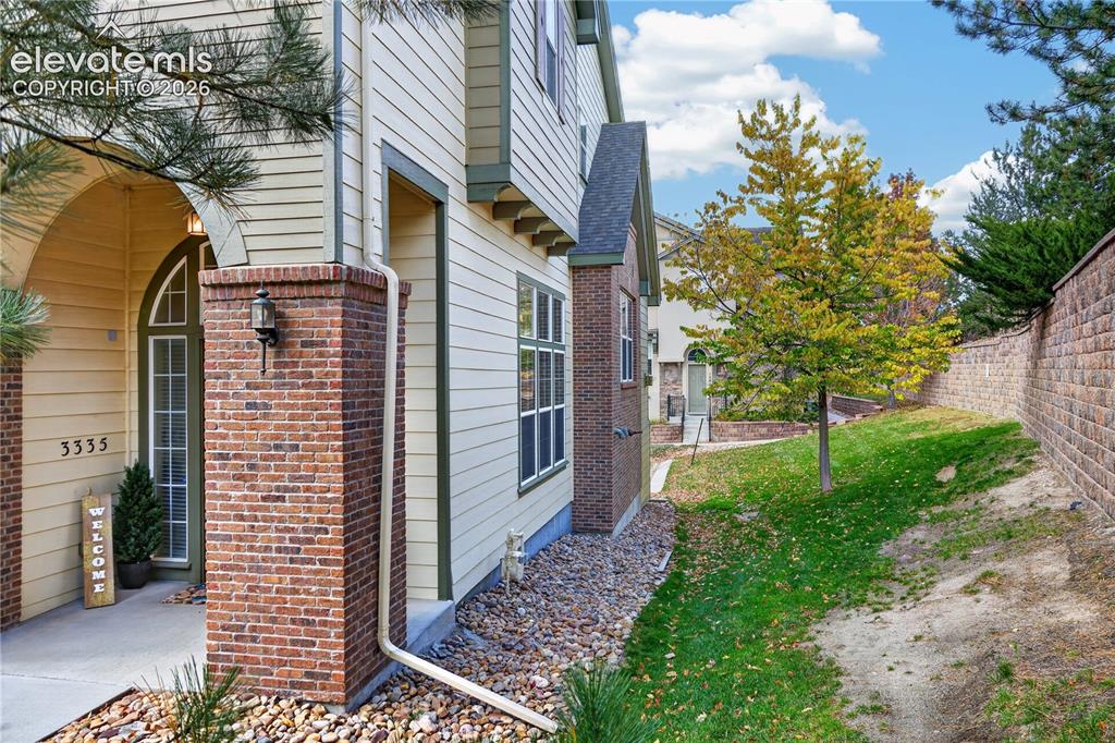 Image 37 of 43: Exterior featuring lap siding, brick masonry detailing, an arched entry, an
