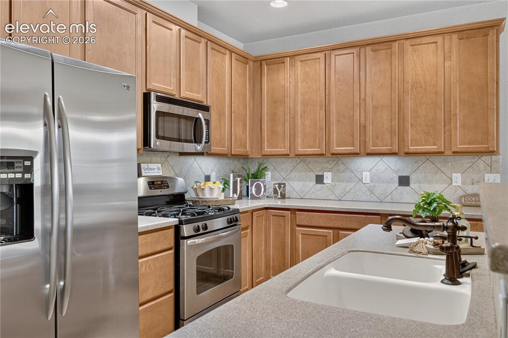 Image 4 of 43: Kitchen featuring shaker-style wood cabinetry, stainless steel appliances,