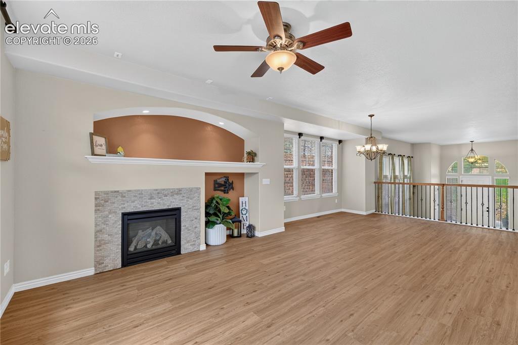 Image 43 of 43: Fireplace with stone-tile surround, arched recessed shelving, wood-finish f