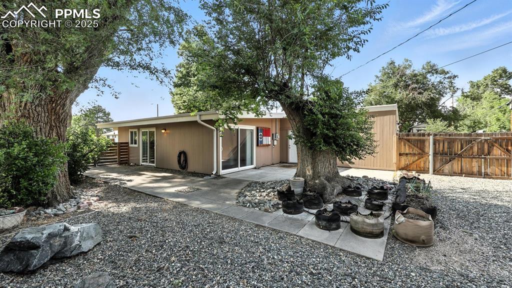 Image 17 of 35: Low maintenance backyard with a wrap around patio, rock gardens, and mature