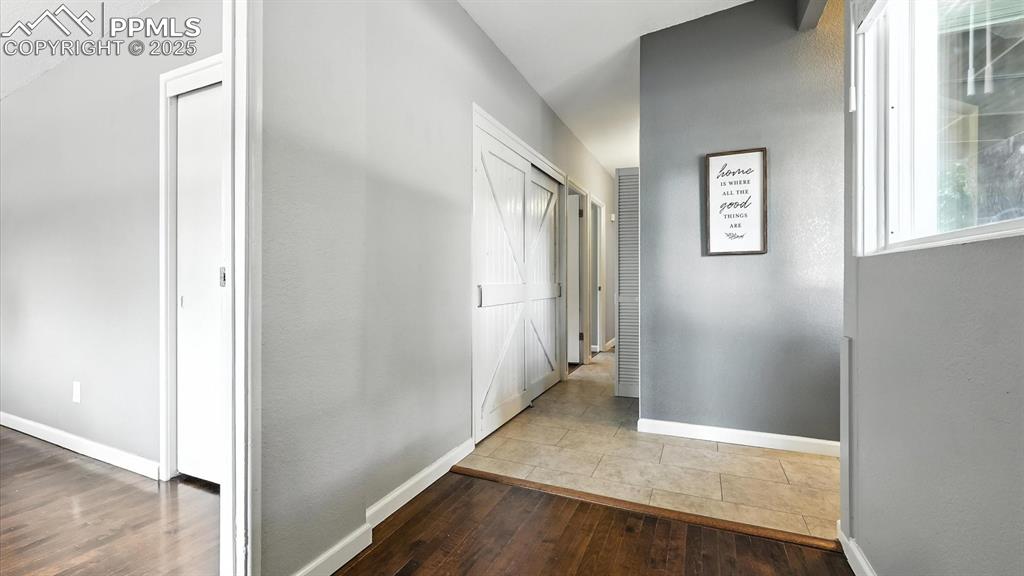 Image 21 of 35: Hallway with custom barn door laundry nook, with washer and dryer included.
