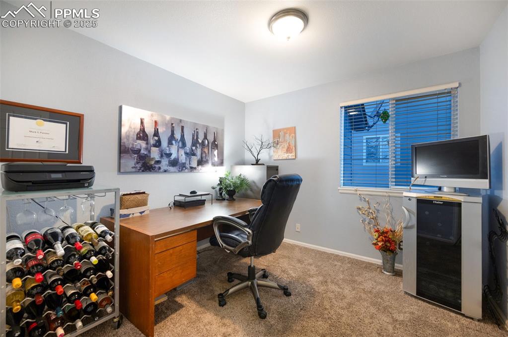 Image 15 of 49: Home office with light colored carpet and baseboards