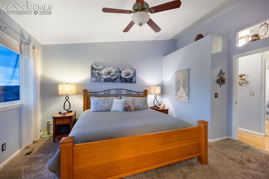 Image 17 of 49: Carpeted main bedroom featuring ceiling fan and baseboards