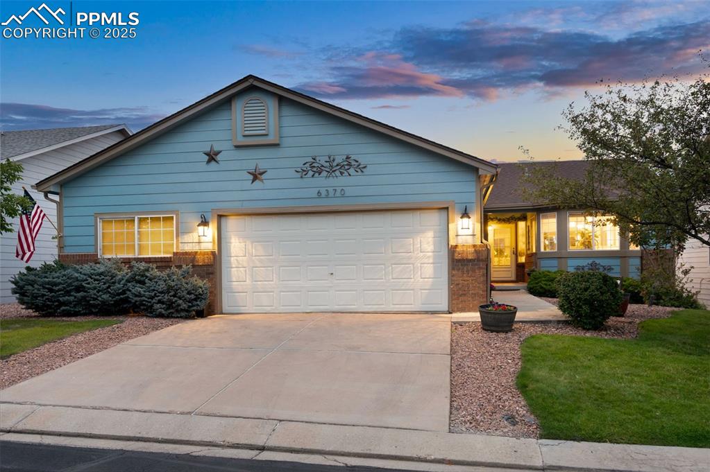 Image 2 of 49: Ranch-style house featuring brick siding, driveway, and a garage