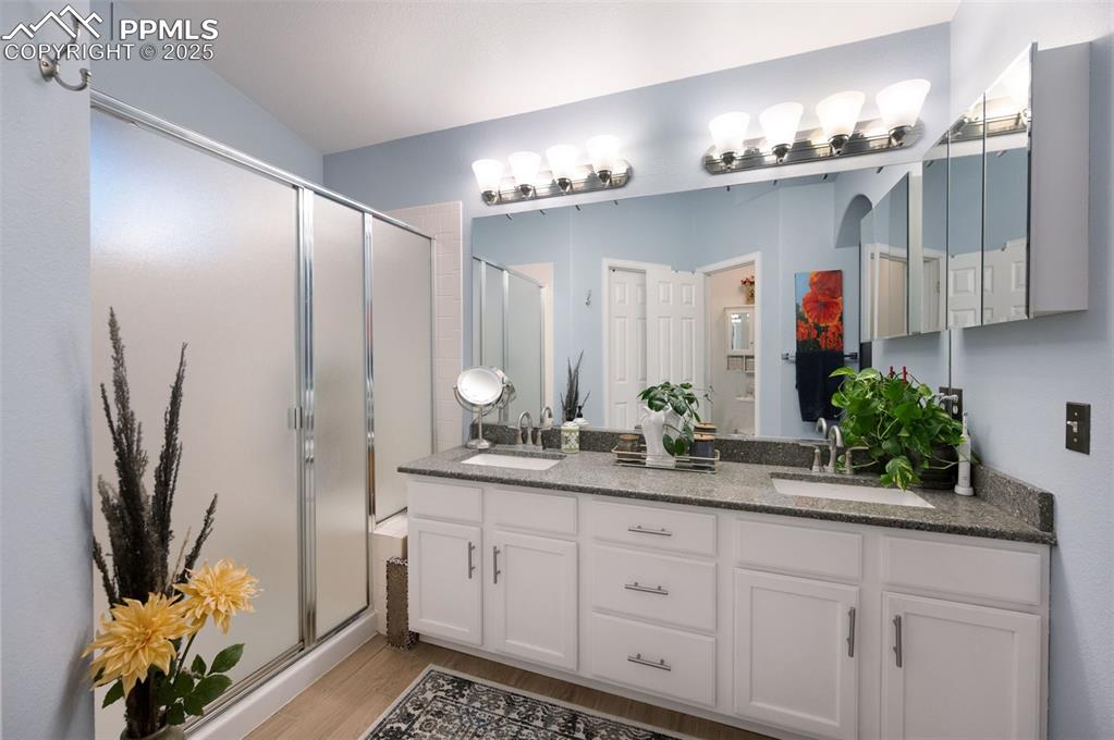 Image 20 of 49: Bathroom featuring a shower stall, light wood finished floors, and double v