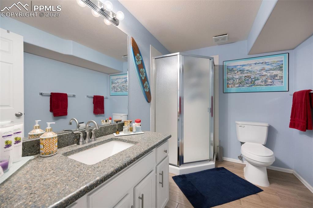 Image 34 of 49: Full bathroom with vanity, a shower stall, and light wood-style flooring