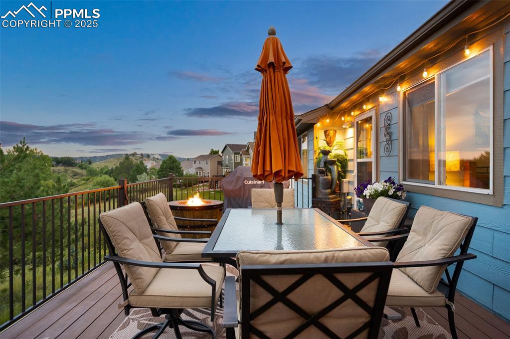 Image 41 of 49: Deck featuring outdoor dining area and a fire pit
