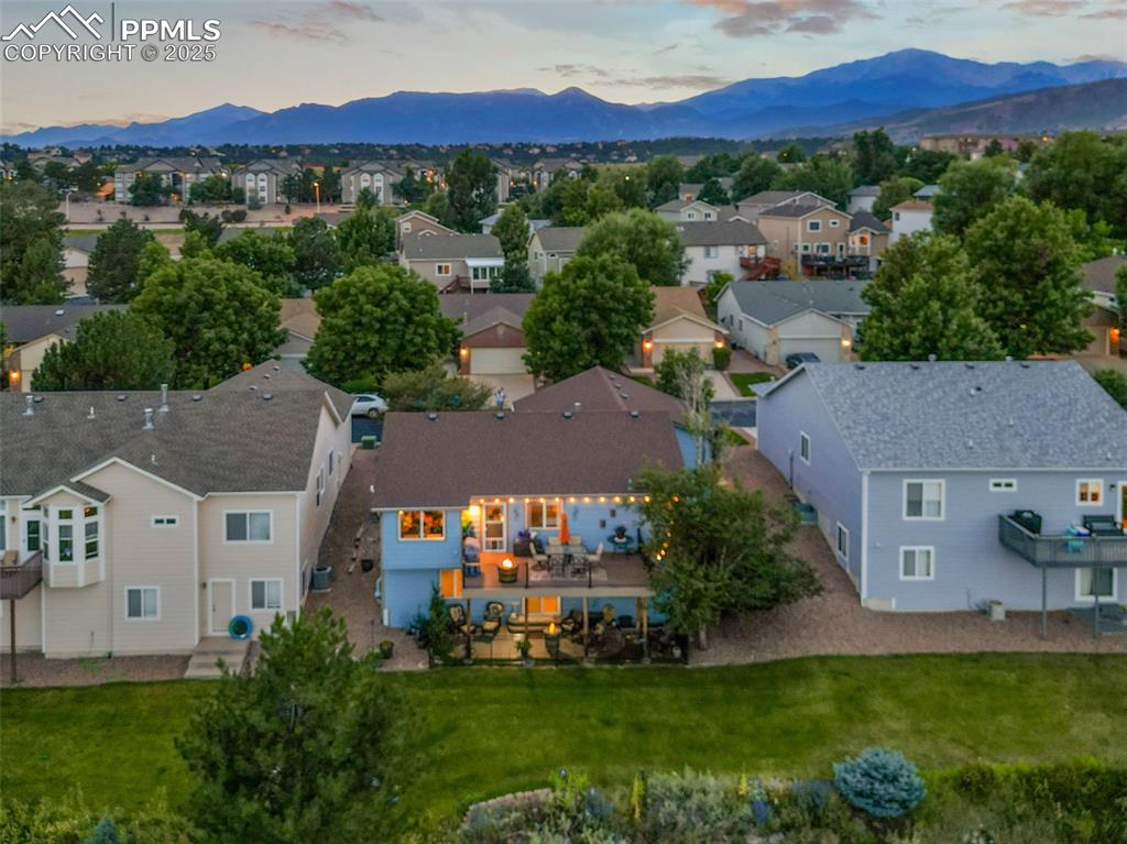 Image 44 of 49: Aerial view at dusk of a residential view and a mountain view