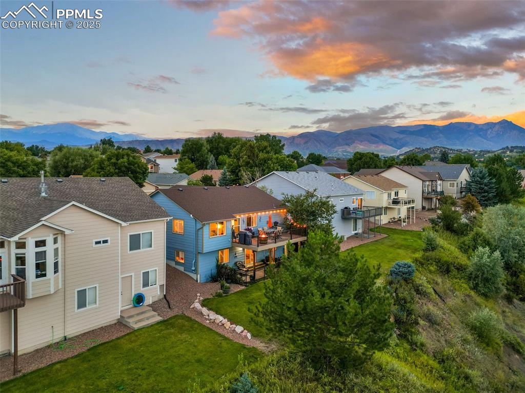 Image 45 of 49: Aerial view at dusk of a residential view and a mountain view