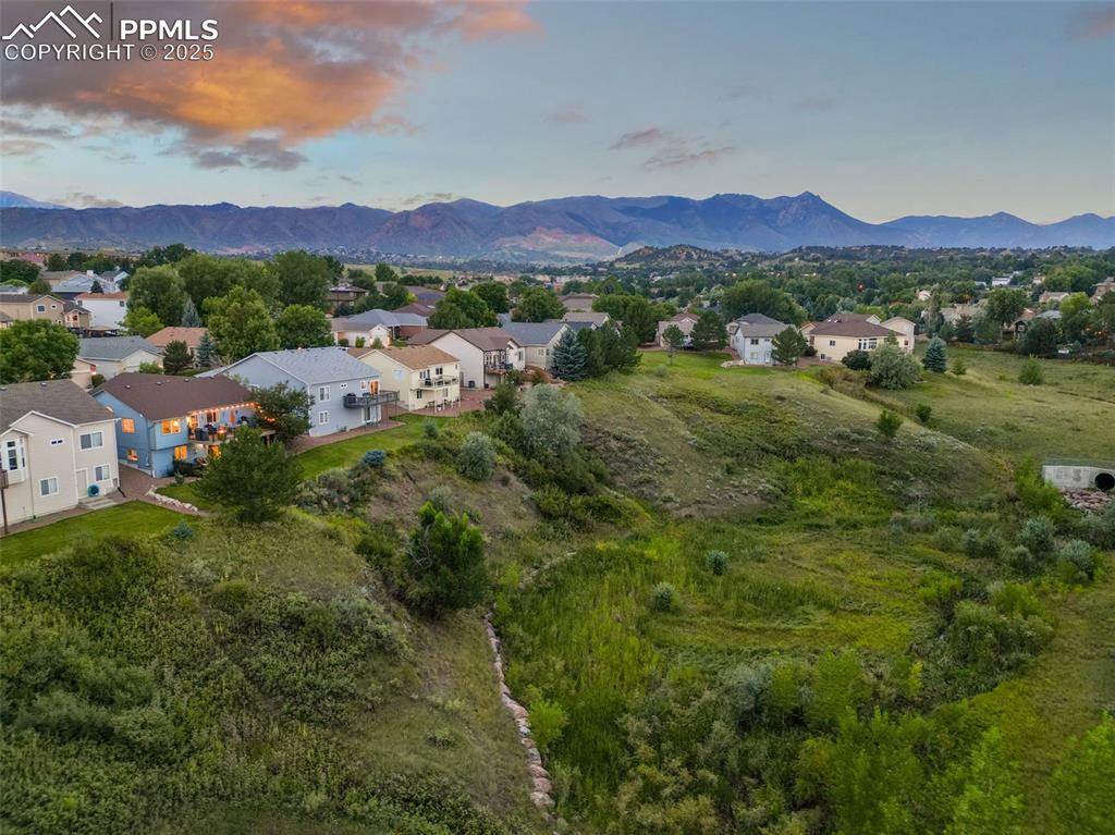 Image 46 of 49: Aerial view at dusk of a residential view and a mountain view