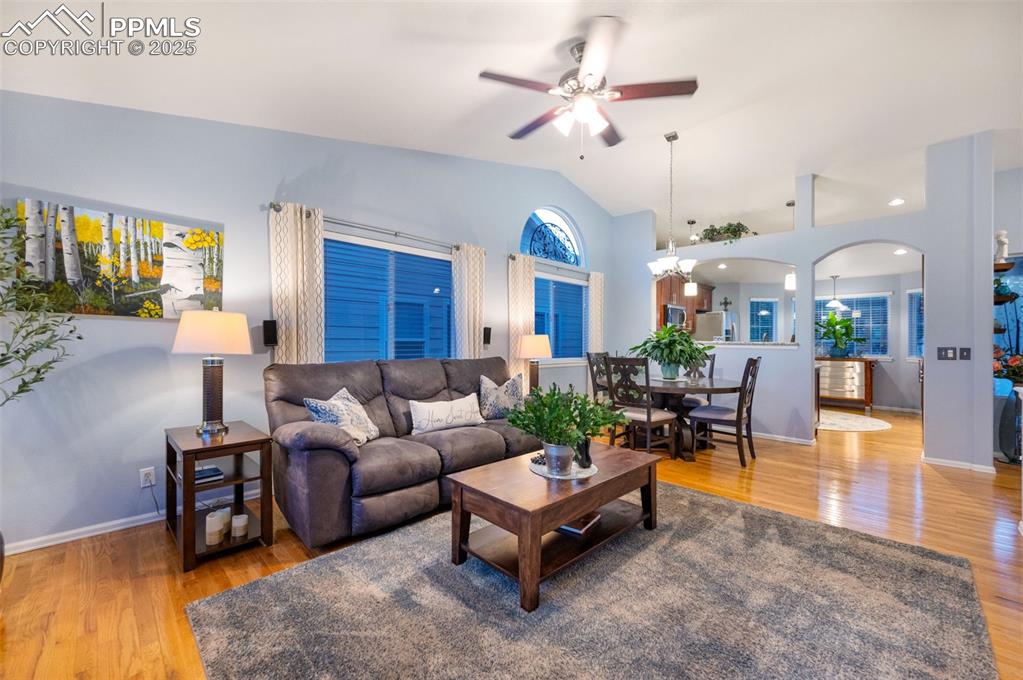 Image 6 of 49: Living area featuring light wood finished floors, lofted ceiling, ceiling f