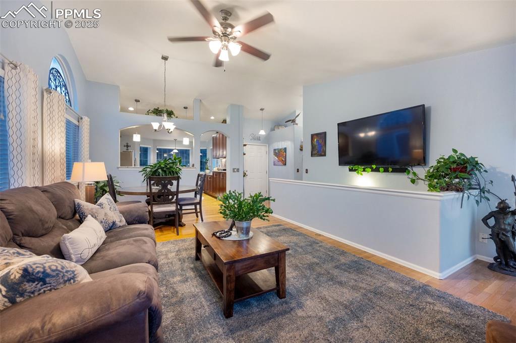 Image 8 of 49: Living area featuring lofted ceiling, wood finished floors,