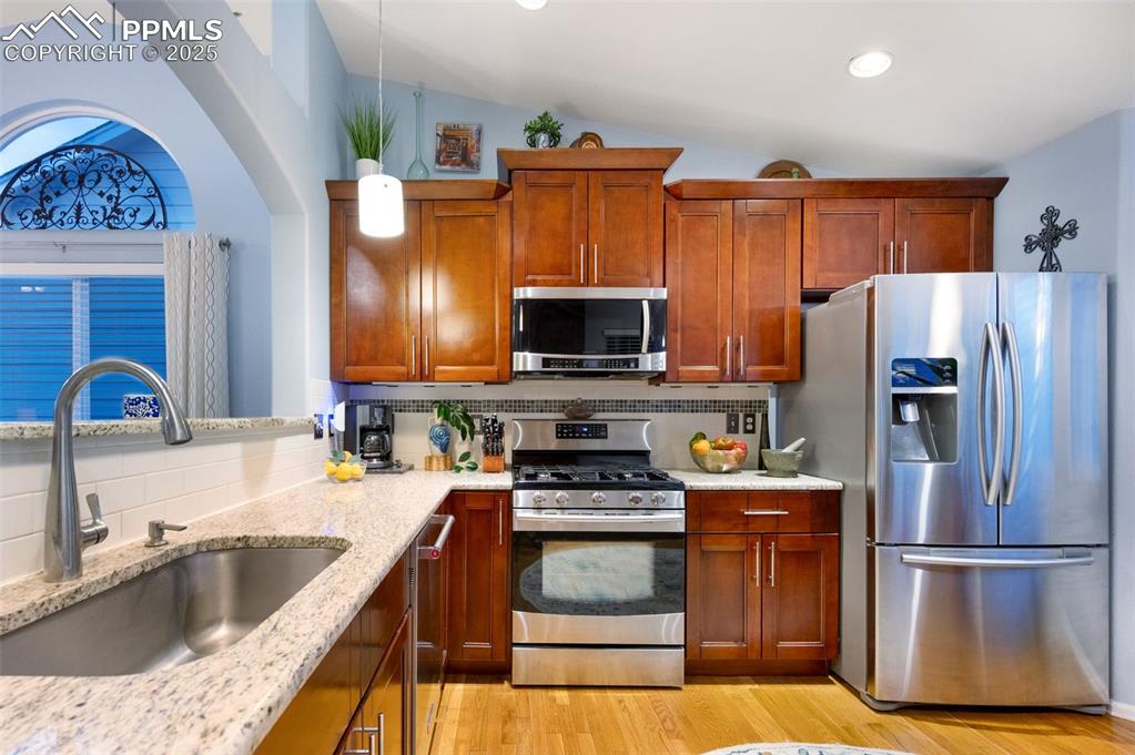 Image 9 of 49: Kitchen with stainless steel appliances, decorative backsplash, brown cabin