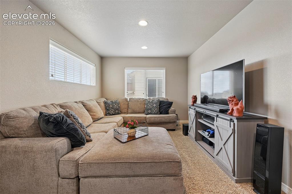 Image 10 of 24: Recessed lighting illuminates this room featuring light-colored walls and c