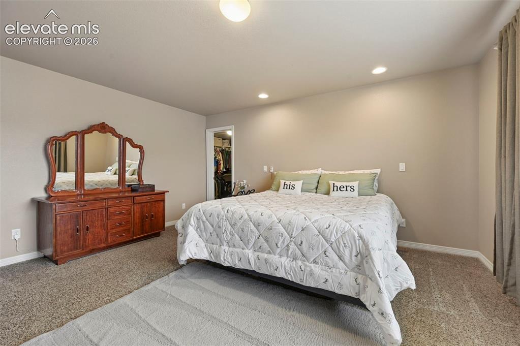 Image 14 of 24: Carpeted bedroom featuring neutral wall tones and a ceiling-mounted light f