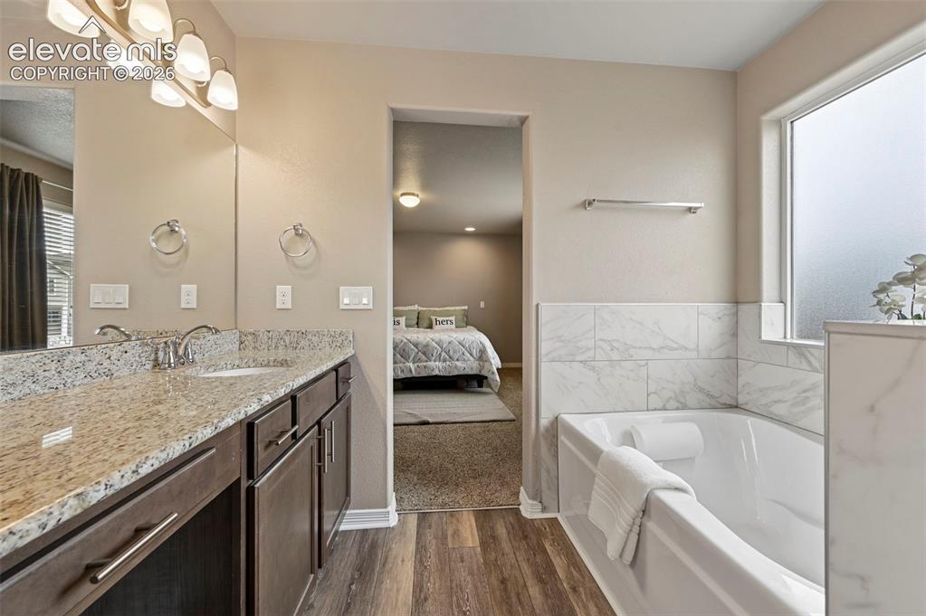 Image 16 of 24: Dual vanity with stone-finish countertop, undermount sinks, and wood-finish