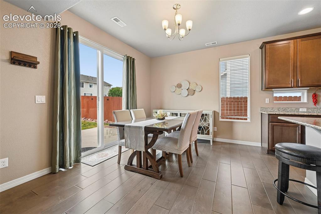 Image 2 of 24: Dining area featuring wood-finish flooring, a sliding glass door to the ext