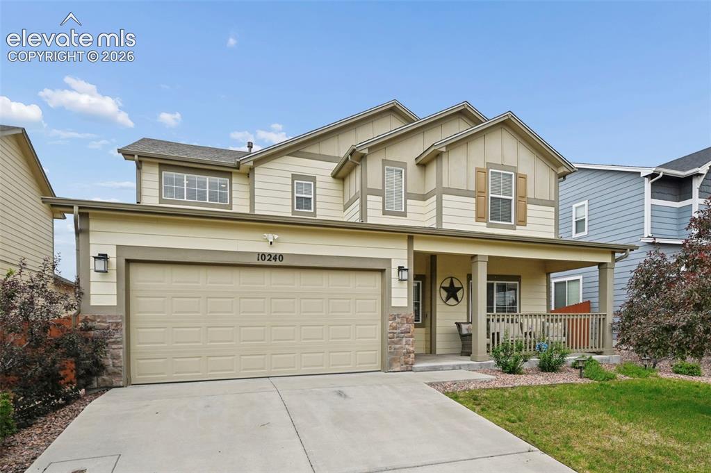 Image 23 of 24: Two-story residence featuring a covered front porch, an attached garage, a