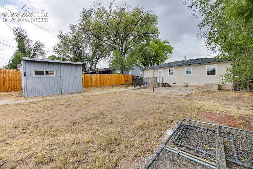 Image 16 of 17: Fenced backyard with RV parking off the alley