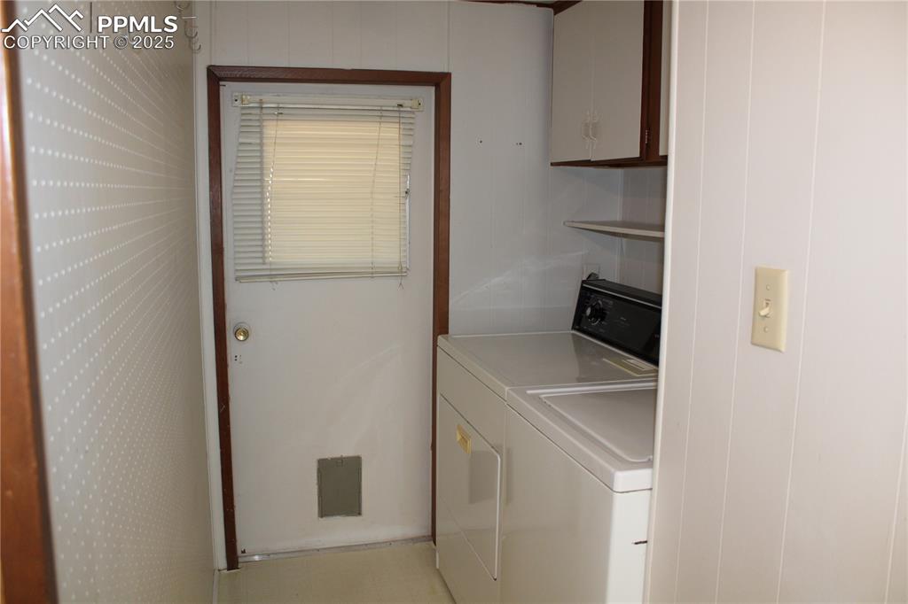 Image 11 of 20: Washroom featuring cabinet space and washing machine and clothes dryer