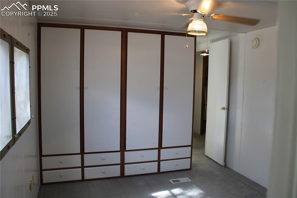 Image 15 of 20: Unfurnished bedroom with carpet flooring and ceiling fan