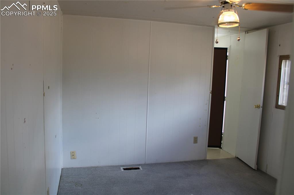 Image 16 of 20: Carpeted spare room with wooden walls