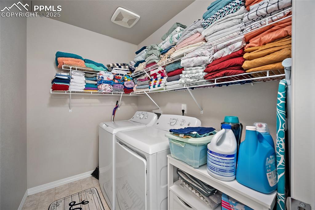 Image 19 of 36: Laundry room with light tile patterned flooring and washing machine and dry