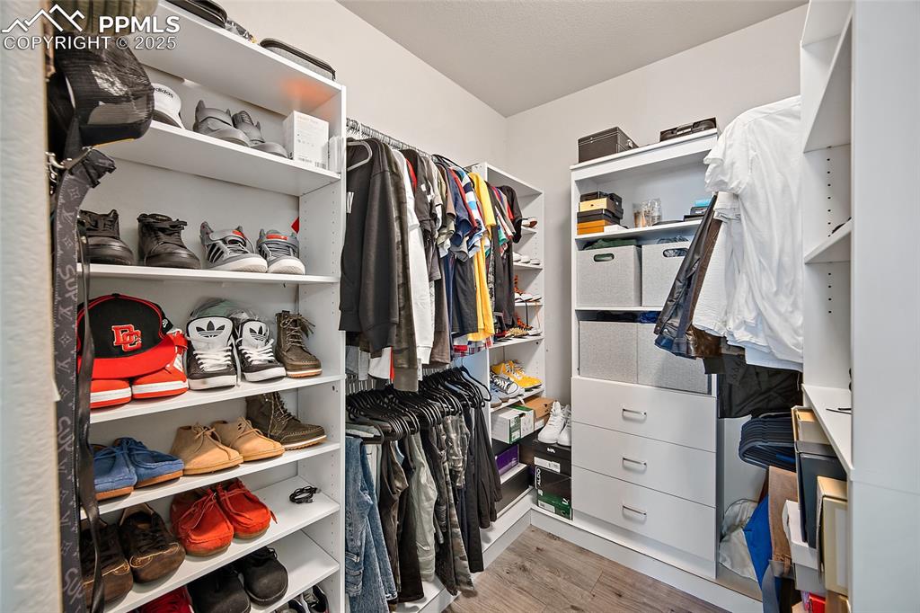 Image 26 of 36: Walk in closet with light wood-style flooring