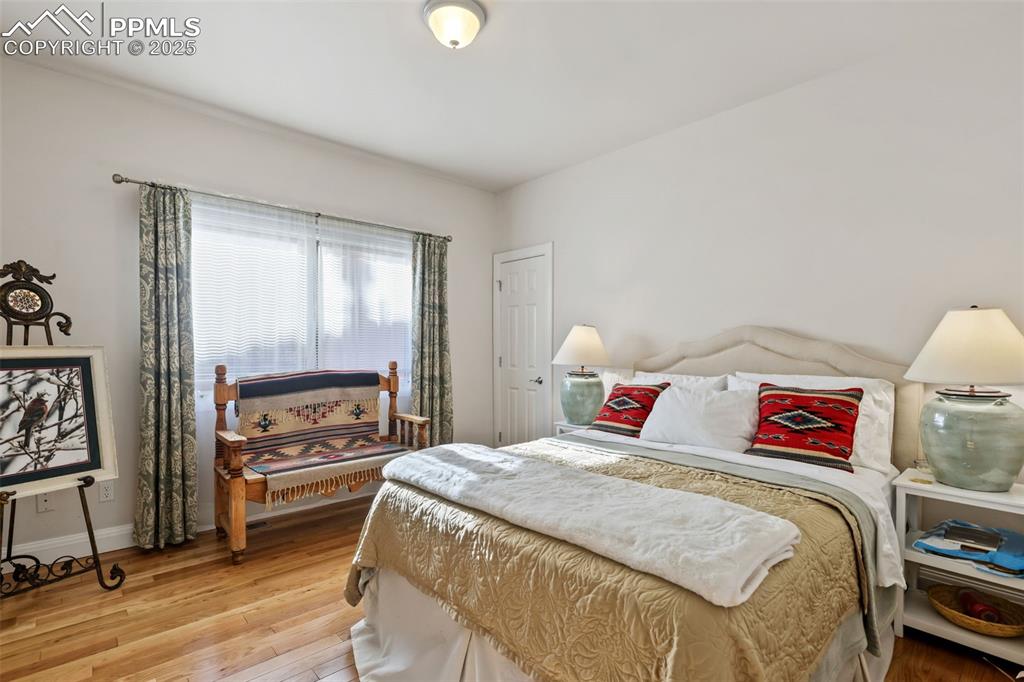 Image 19 of 37: Second main-level bedroom with hardwood floors