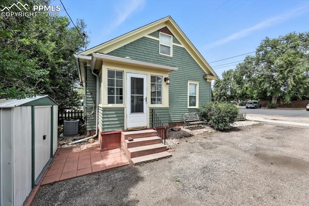 Image 16 of 48: Back of house with a storage unit and a patio