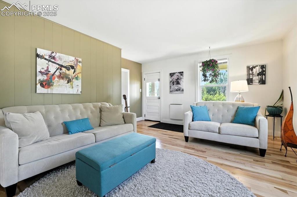 Image 3 of 48: Living room featuring light wood-style flooring and wood walls