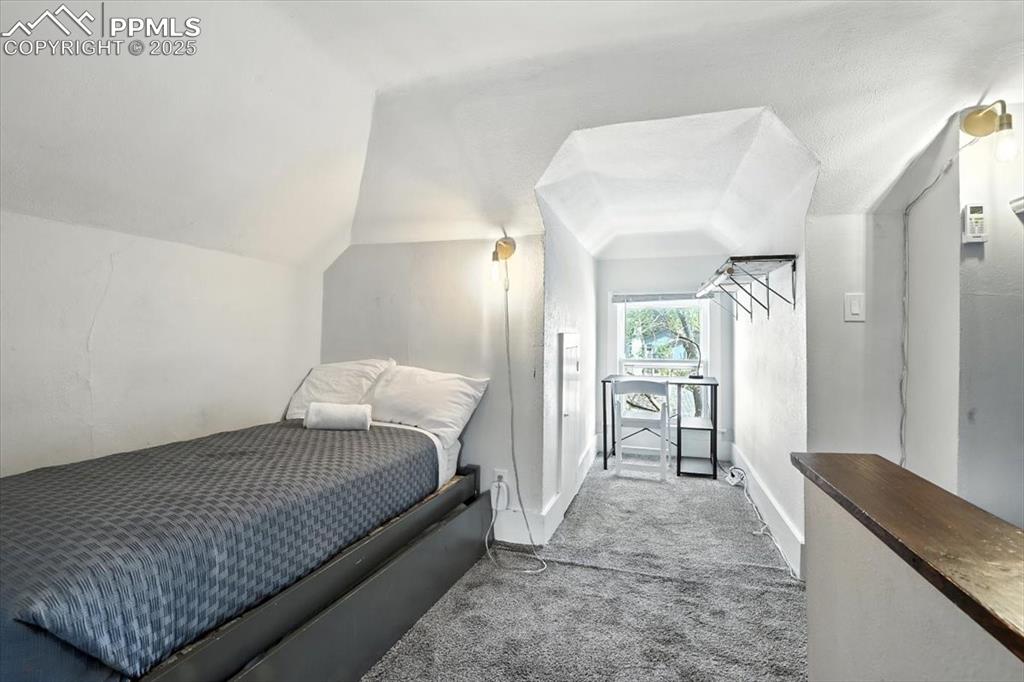Image 32 of 48: Bedroom featuring carpet and vaulted ceiling