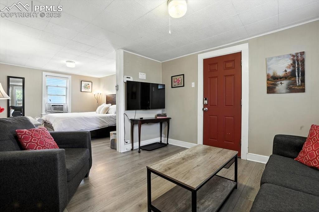 Image 37 of 48: Living room featuring wood finished floors and crown molding