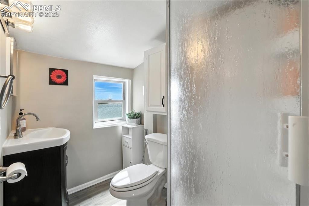 Image 39 of 48: Full bath with vanity, a shower stall, and light wood-type flooring