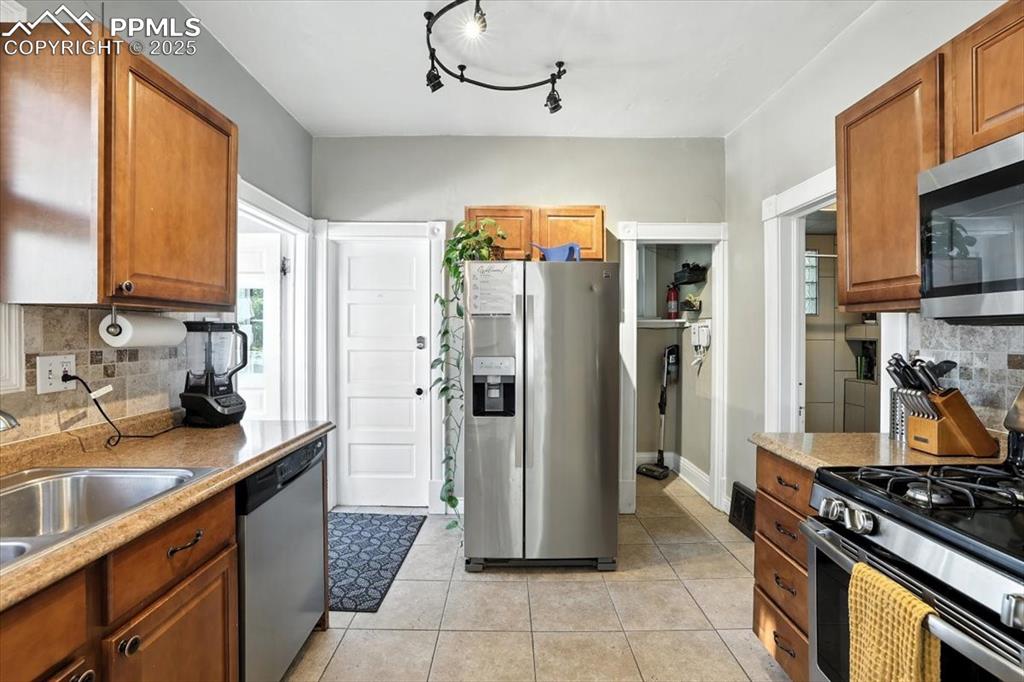 Image 4 of 48: Kitchen with decorative backsplash, appliances with stainless steel finishe