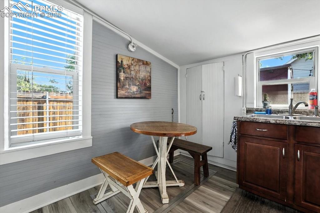 Image 42 of 48: Dining area featuring dark wood finished floors, wood walls, and lofted cei