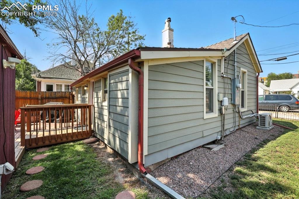 Image 44 of 48: View of side of property with a deck and a chimney