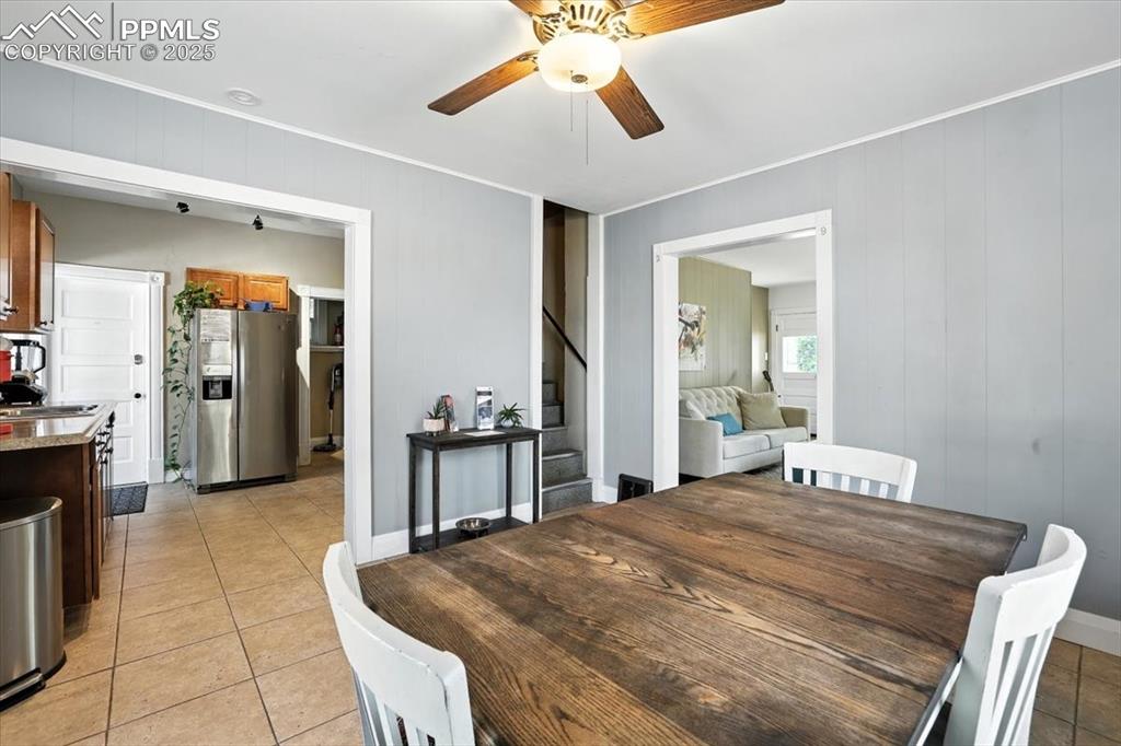 Image 7 of 48: Dining area featuring light tile patterned floors, a ceiling fan, stairway,