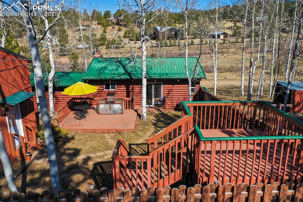 Image 18 of 38: Fenced backyard with multiple decks.