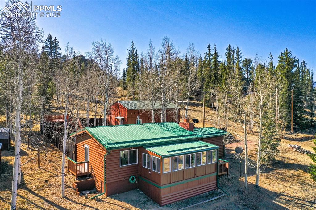 Image 23 of 38: View of front of property with metal roof and faux log siding