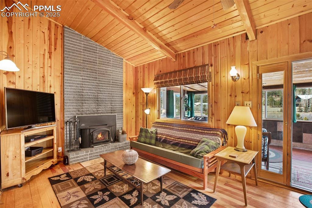 Image 5 of 38: Living area featuring vaulted ceiling with beams, plenty of natural light, 