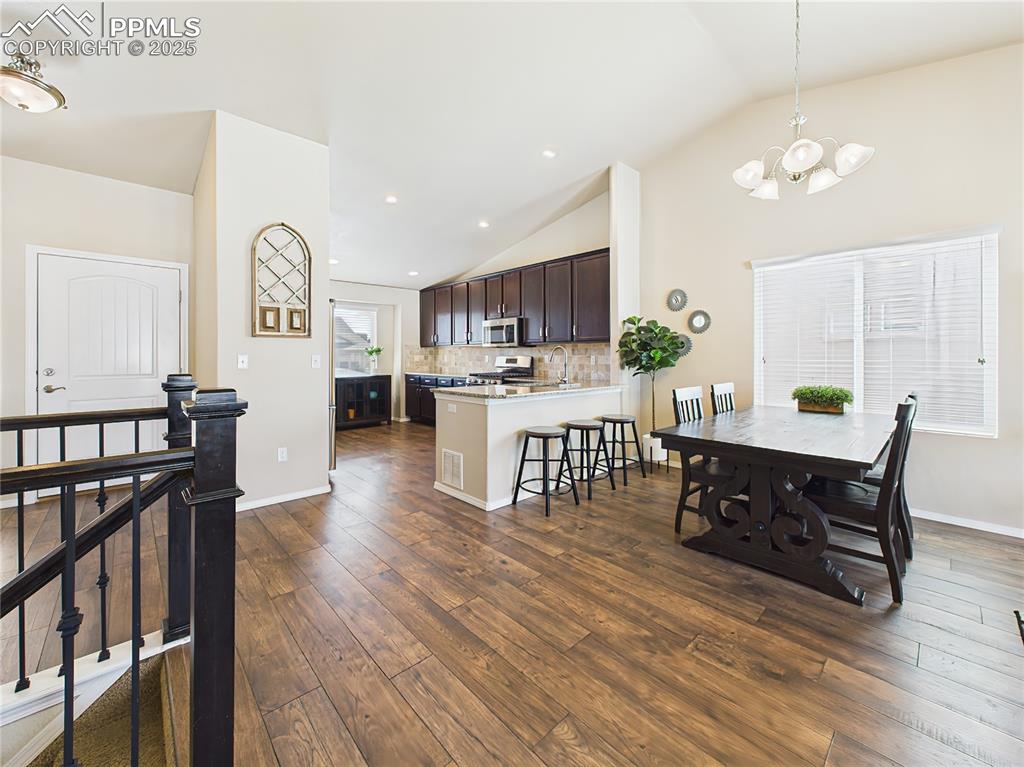 Image 10 of 50: Elegant dining area adjacent to the kitchen with updated lighting and easy 
